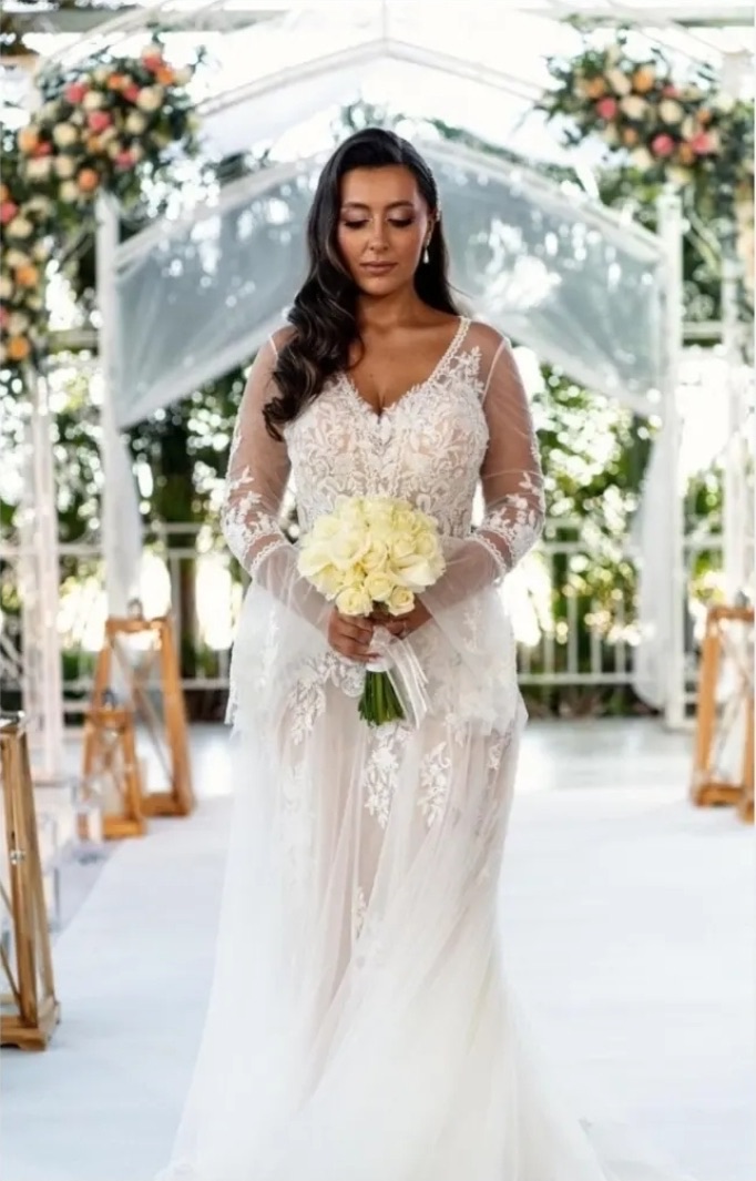 Bride with white roses beneath a floral arch
